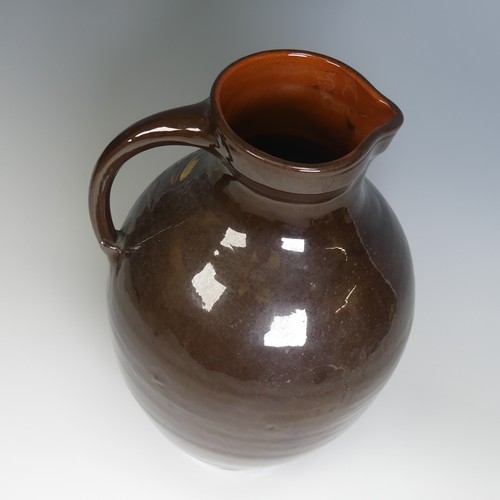 64 - A William Baron for C. H. Brannam pottery Jug, of large size, with dark brown ground decorated in sw... 