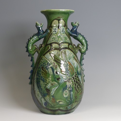 67 - A C. H. Brannam pottery twin-handled Vase, with bulbous body and flared rim, decorated with intertwi... 