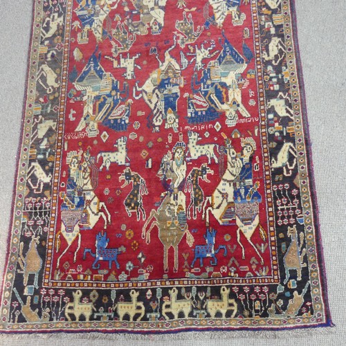 768 - Tribal rugs; a hand-knotted Persian Kashgai pictorial rug, red-ground depicting hunting scenes, wool... 