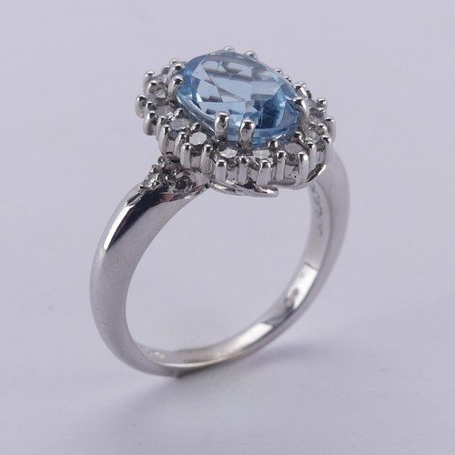  An aquamarine and diamond cluster Ring, the oval facetted aquamarine approx. 9.68mm long, within a s... 