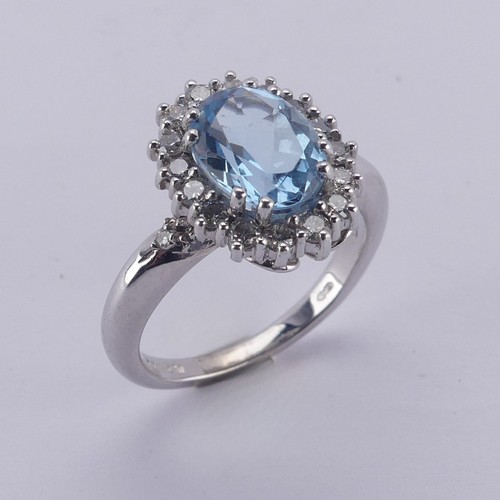  An aquamarine and diamond cluster Ring, the oval facetted aquamarine approx. 9.68mm long, within a s... 