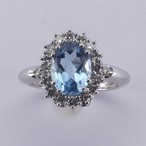  An aquamarine and diamond cluster Ring, the oval facetted aquamarine approx. 9.68mm long, within a s... 