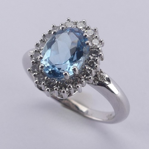  An aquamarine and diamond cluster Ring, the oval facetted aquamarine approx. 9.68mm long, within a s... 