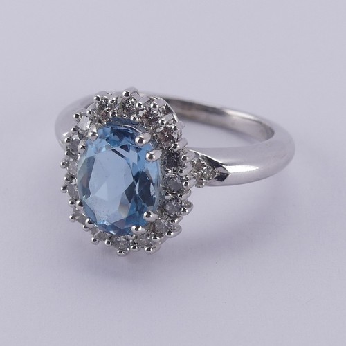  An aquamarine and diamond cluster Ring, the oval facetted aquamarine approx. 9.68mm long, within a s... 