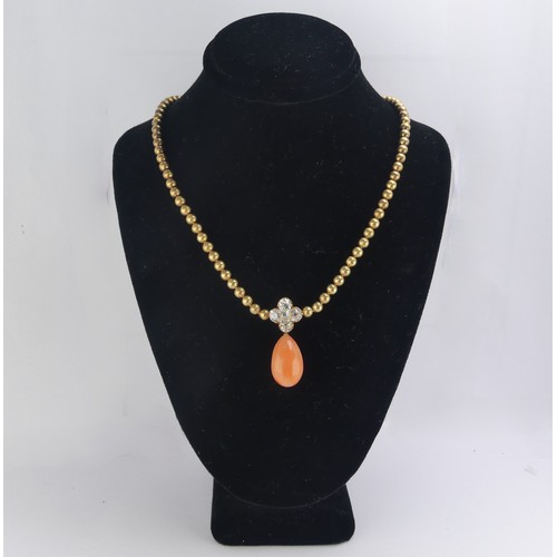 An Edwardian pink coral and diamond Necklace, the pear shaped coral drop with cushion cut diamond cluster surmount, total diamond weight approx. 1.15ct, on an integral gold ball chain necklace, with barrel snap, unmarked, tested as 9ct gold, 36cm long, total weight 25g, in original fitted presentation case, the necklace having oreviously been shortened so cannot be fastened into case.