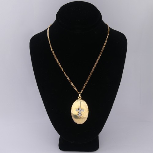 A 9ct yellow gold oval hinged Locket, the front with applied white gold Fleur-de-lys, set diamond points, 3.3cm long, on a 9ct gold curb link chain 45cm long, total weight 12.8g.