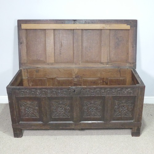 10 - An 18th century oak four-panel Coffer, the front carved in relief with floral decoration, raised on ... 
