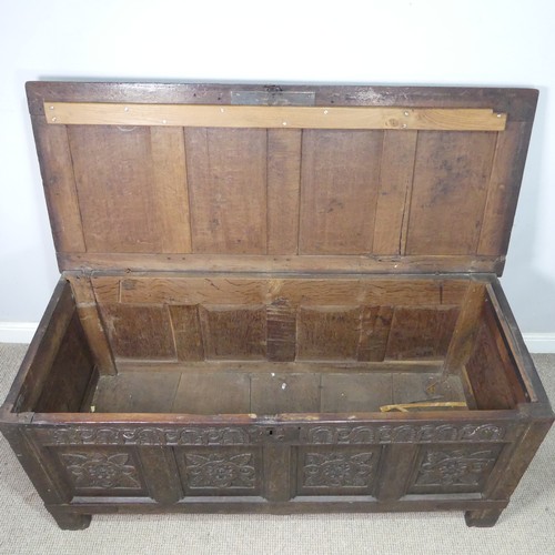 10 - An 18th century oak four-panel Coffer, the front carved in relief with floral decoration, raised on ... 