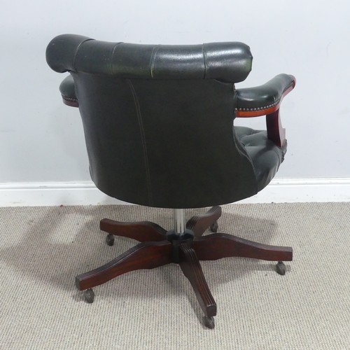 118 - A 20th century green leather captain's desk Chair, raised on a reeded swivel base and castors, W 72 ... 