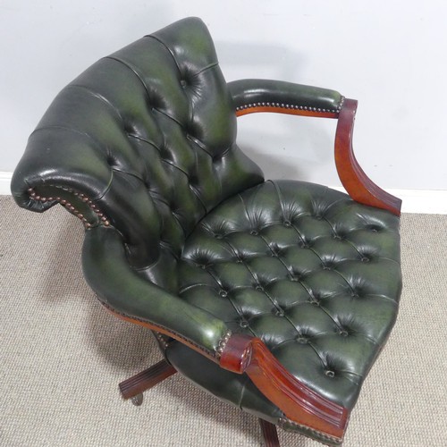 118 - A 20th century green leather captain's desk Chair, raised on a reeded swivel base and castors, W 72 ... 
