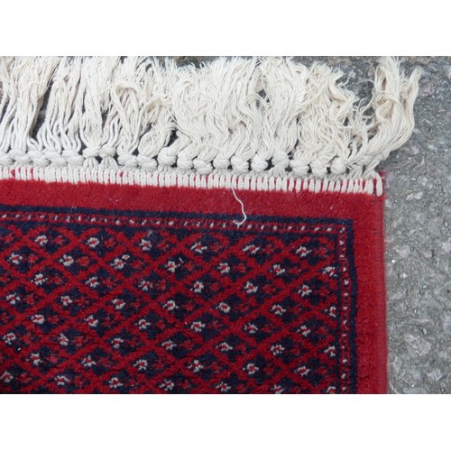 294 - A large red ground Bokhara style machine-made 'Super-Kashan' carpet, in good condition, 320cm x 200c... 