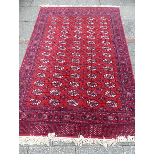 294 - A large red ground Bokhara style machine-made 'Super-Kashan' carpet, in good condition, 320cm x 200c... 