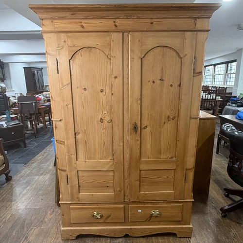 114 - A late 19th century stripped pine Wardrobe, the moulded cornice above two arched panel doors, W 119 ... 
