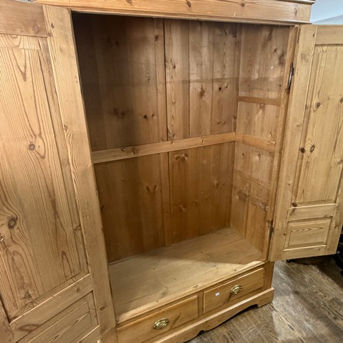 114 - A late 19th century stripped pine Wardrobe, the moulded cornice above two arched panel doors, W 119 ... 