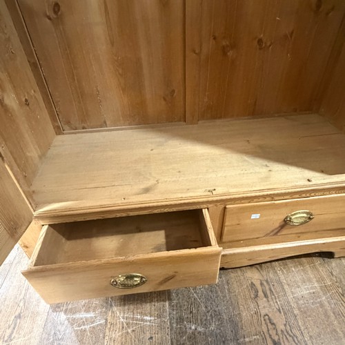 114 - A late 19th century stripped pine Wardrobe, the moulded cornice above two arched panel doors, W 119 ... 