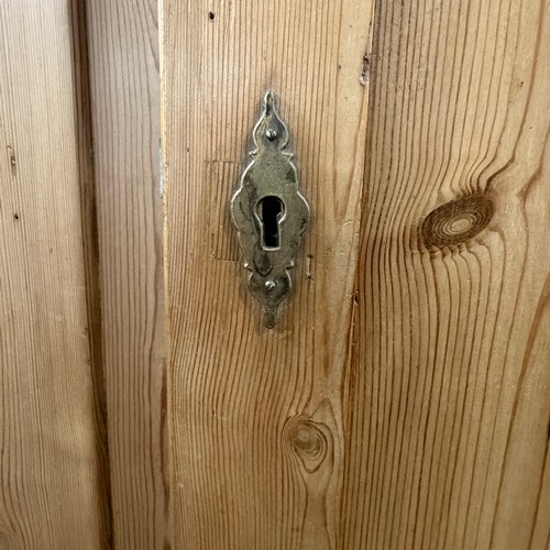 114 - A late 19th century stripped pine Wardrobe, the moulded cornice above two arched panel doors, W 119 ... 