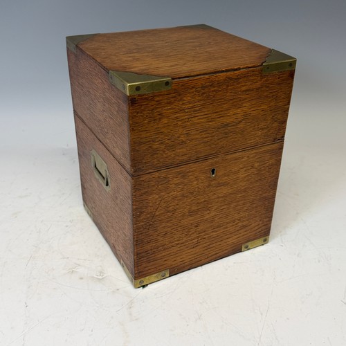 102 - A Victorian oak brass bound Tantalus, with fitted red baize interior, and inset brass swing handles,... 