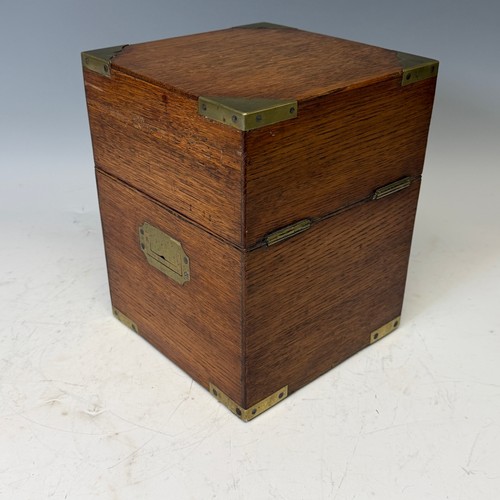 102 - A Victorian oak brass bound Tantalus, with fitted red baize interior, and inset brass swing handles,... 