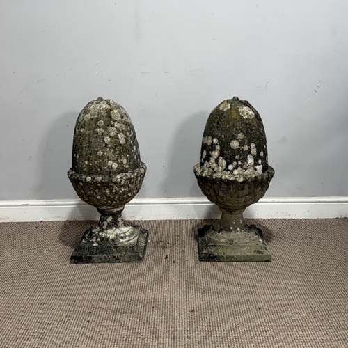 106 - A pair of weathered reconstituted stone pier Acorns, W 32 cm x H 65 cm x D 32 cm, together with a re... 