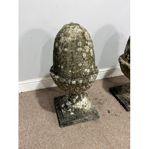 106 - A pair of weathered reconstituted stone pier Acorns, W 32 cm x H 65 cm x D 32 cm, together with a re... 
