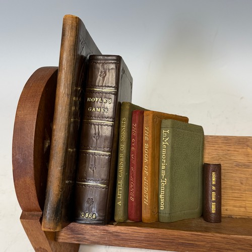 221 - An Arts & Crafts oak book Trough, W 40 cm x H 20 cm x D 16 cm, together with seven pocket Books ... 