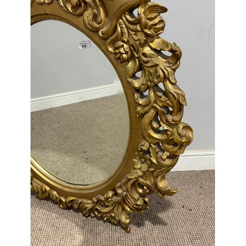 224 - A Louis XVI style gilt painted wall Mirror, the oval bevelled mirror plate in a profusely decorated ... 