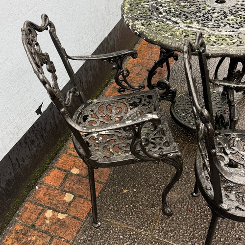 173 - A cast and painted circular garden Table, decorated with stylised leaves and scrolls, the under-tier... 