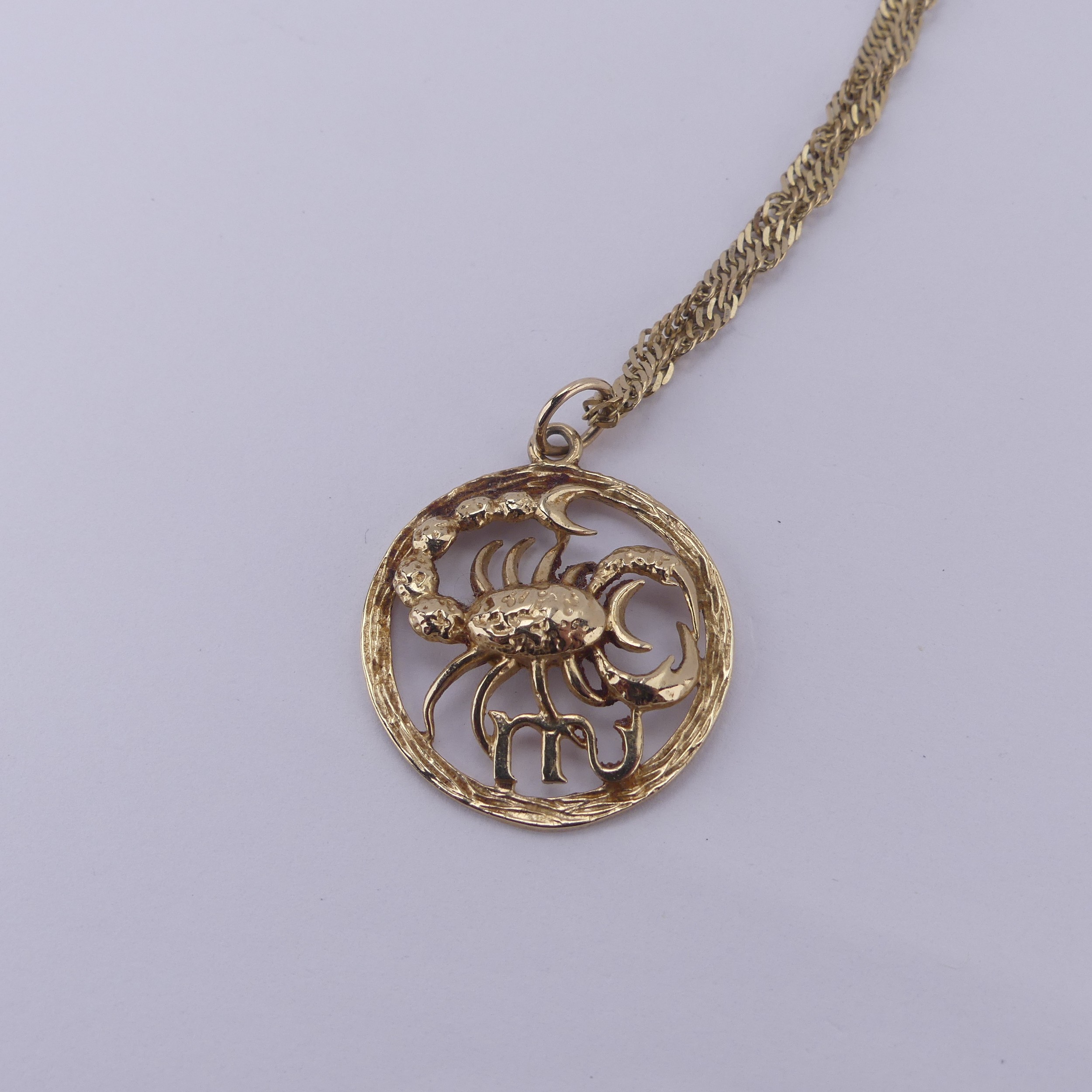 A 9ct yellow gold Zodiac 'Cancer' Pendant, 24mm diameter, on a 9ct gold ...