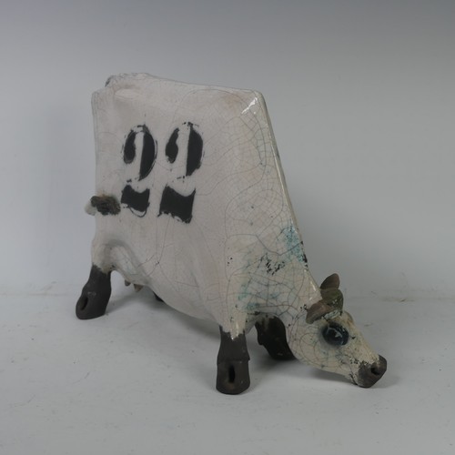 93A - Lawson E. Rudge (b. 1936),&nbsp;a raku fired, studio pottery sculpture of a Grazing Cow, with crackl... 
