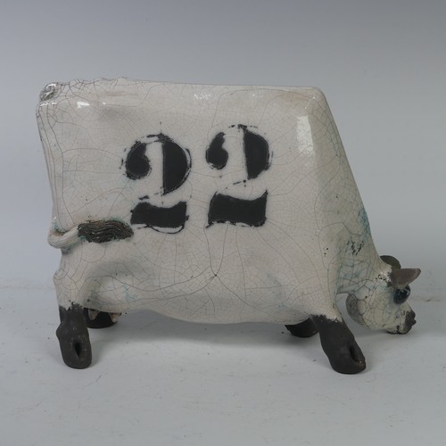 93A - Lawson E. Rudge (b. 1936),&nbsp;a raku fired, studio pottery sculpture of a Grazing Cow, with crackl... 
