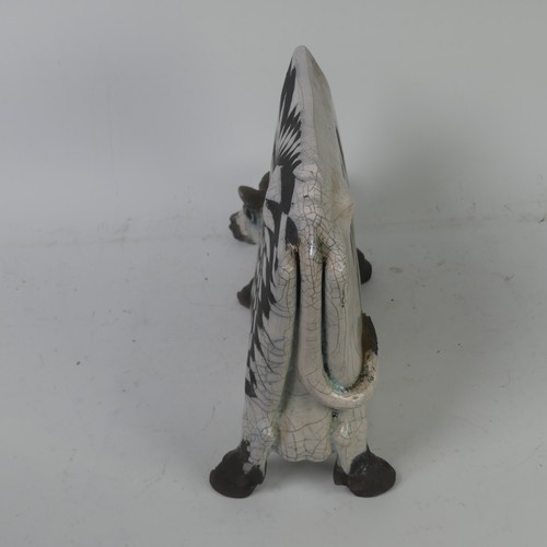 93A - Lawson E. Rudge (b. 1936),&nbsp;a raku fired, studio pottery sculpture of a Grazing Cow, with crackl... 