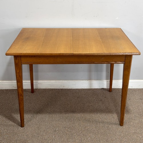 14 - A Gordon Russell oak extending dining Table, retailed by Heals of London, raised on tapering support... 