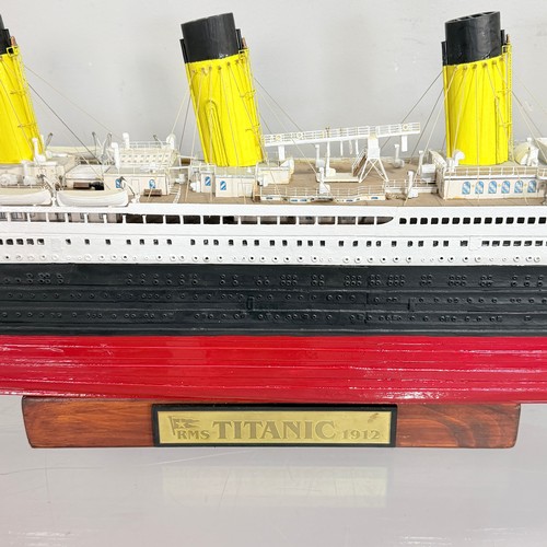 51 - A scratch built wooden and painted Model of the RMS Titanic, displayed on a wooden plinth, L 105 cm,... 