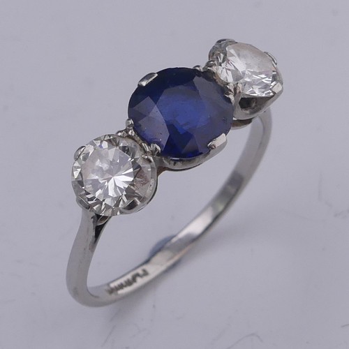 A sapphire and diamond three stone Ring, the central oval facetted sapphire approx. 1.39ct (6.86mm diameter), with a brilliant cut diamond on either side, each approx. 0.53ct, all claw set in platinum, Size M&frac12;, 3g.