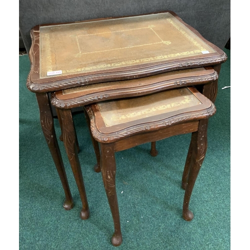 355 - A NEST OF THREE DARK WOOD TABLES WITH LEATHER INSET