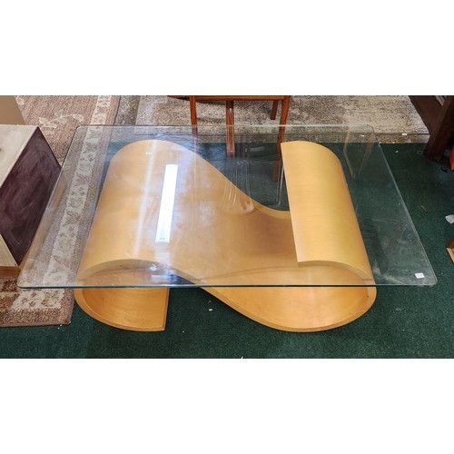 341 - A RECTANGULAR GLASS TOPPED COFFEE TABLE WITH BEECH SCROLL SUPPORTS