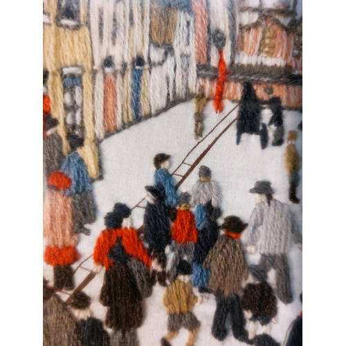 51 - After L.S Lowry- The Organ Grinder - A Wool work depiction of Lowry's famous painting copied in grea... 