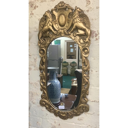 350 - HEAVILY FRAMED GILT MIRROR WITH FOLIATE EDGE DESIGN SURMOUNTED BY GRIFFINS