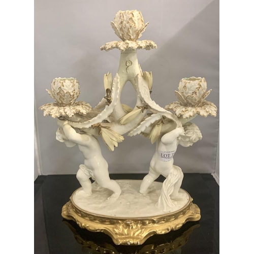 356 - A WHITE & GILT PORCELAIN TRIO CANDLESTICK WITH CHERUBS ON BASE BY MOORE OF STOKE ON TRENT