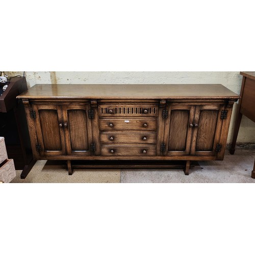 351 - AN ERCOL YEW SIDEBOARD OF 4 CENTRAL DRAWERS (INCL. CUTLERY DRAWER) FLANKED BY TWO DOUBLE DOOR CUPBAO... 