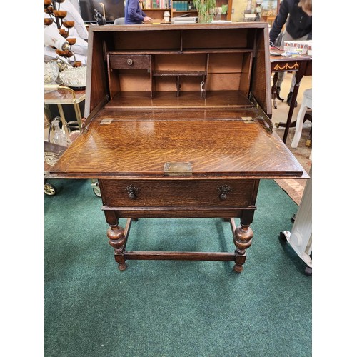207 - SMALL OAK DROP FRONT BUREAU WITH TWO DRAWERS ON RAISED LEGS WITH STRETCHERS