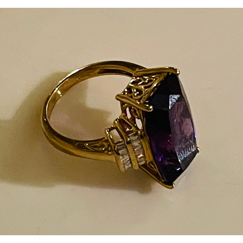365 - A 9ct YELLOW GOLD DRESS RING WITH LARGE FACETED AMETHYST STONE FLANKED BY BAGUETTE CUT DIAMONDS TO T... 