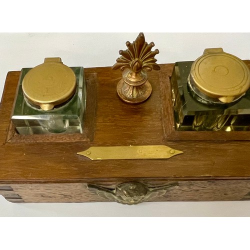 213 - AN OAK CASE INK STAND -WITH A PAIR OF BRASS LIDDED CUT GLASS GLASS INKWELLS THE CASE WITH A COPPER F... 