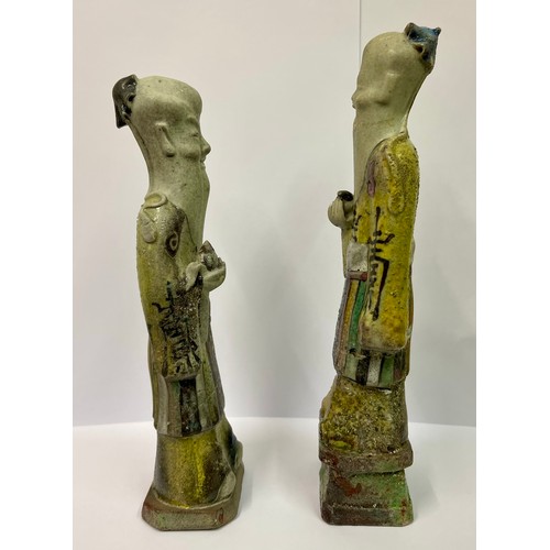 274 - TWO (2) CHINESE FIGURINES -ROUGH CAST  GLAZED WITH CHINESE CHARACTERS INSCRIBED TO THE ROBES -1 WITH... 