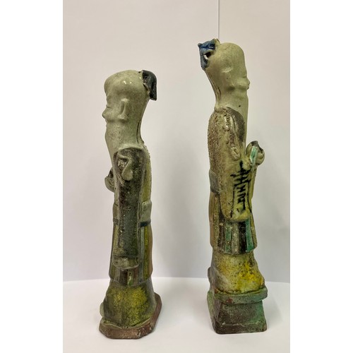 274 - TWO (2) CHINESE FIGURINES -ROUGH CAST  GLAZED WITH CHINESE CHARACTERS INSCRIBED TO THE ROBES -1 WITH... 