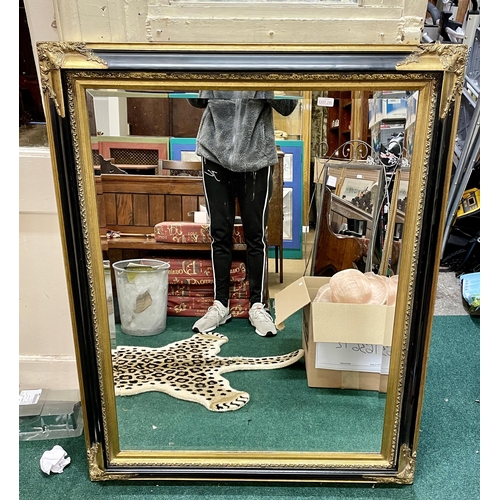 241 - A LARGE BLACK AND GILT ORNATE GALLERY FRAMED MIRROR WITH BEVELLED EDGES - 120CM WIDE X 93CM HIGH