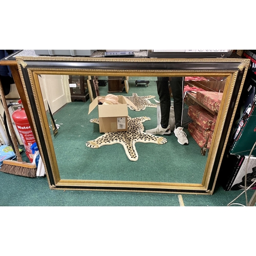 242 - A LARGE BLACK AND GILT GALLERY FRAMED MIRROR WITH BEVELLED EDGES - 120CM WIDE X 93CM HIGH