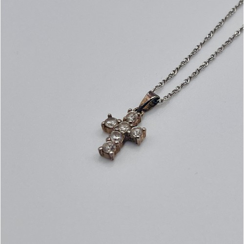 354 - A SMALL SILVER CUBIC ZIRCONIA CROSS ON A SILVER CHAIN- CHAIN MARKED 