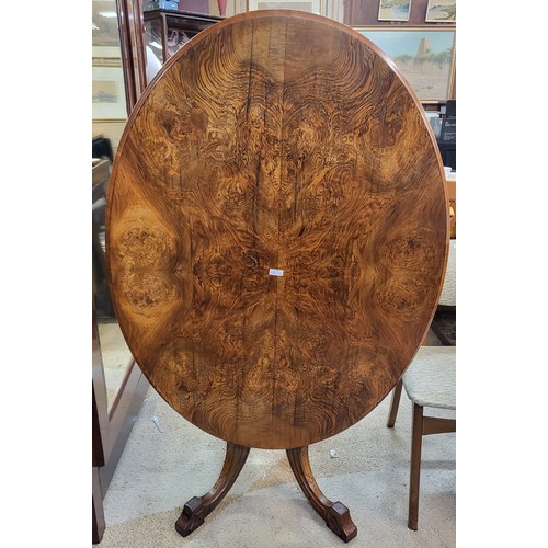 294 - A VICTORIAN FIGURED BURR WALNUT OVAL TILT TOP LOO TABLE RAISED ON FOUR TURNED SUPPORTS AND FOUR CARV... 