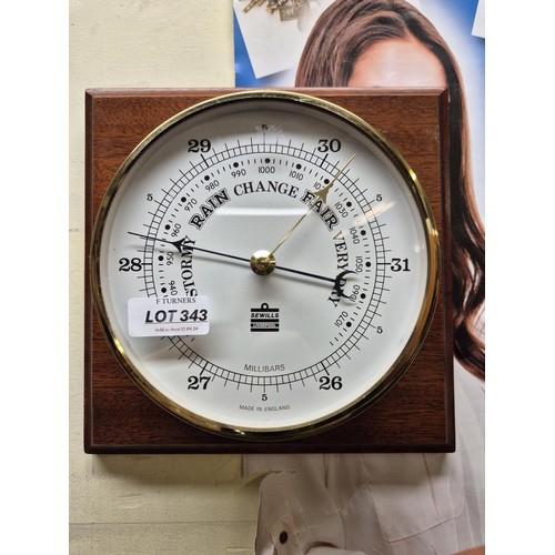 343 - SEWILLS OF LIVERPOOL: BRASS BAROMETER MOUNTED ON A HARDWOOD BASES - BAROMETER D:18CMS HARDWOOD BASES... 